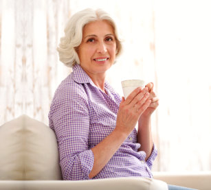 elderly woman holding a cup of coffee